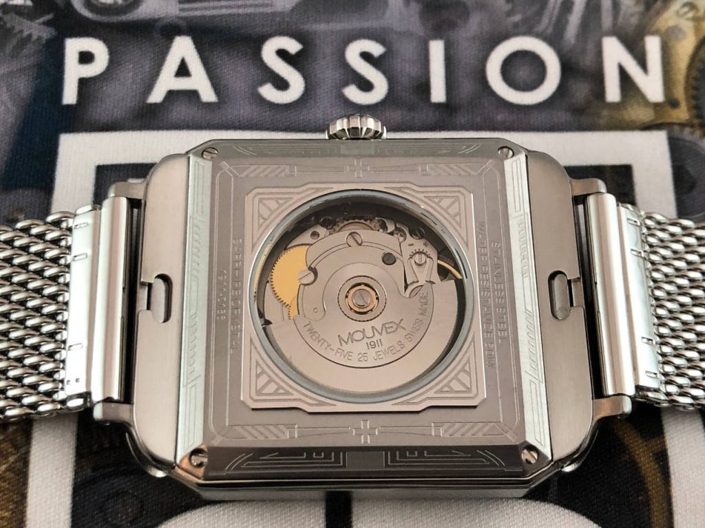 Un fond de boîte gravé et laissant apparaître le mouvement décoré