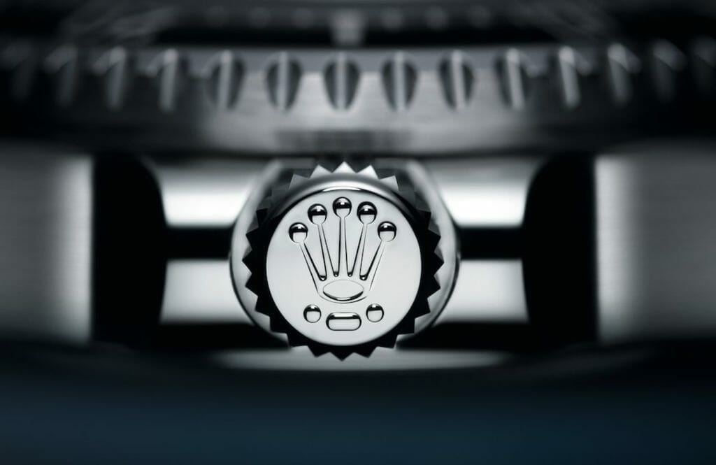 Point-barre-point, les trois marques indiquant que la couronne de remontoir de l’Oyster Perpetual Deepsea Challenge est réalisée en titane RLX.