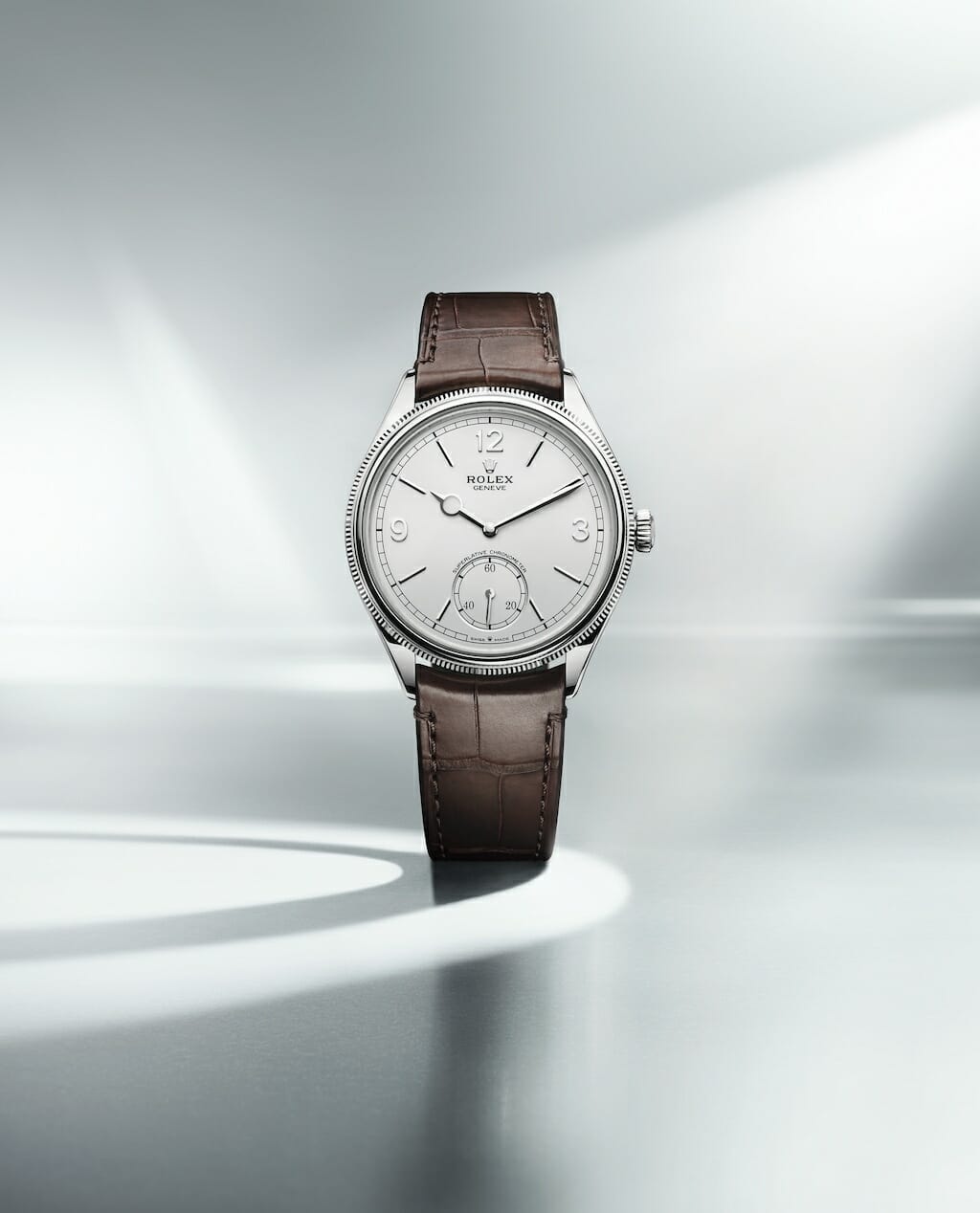 Cadran blanc intense mat, finition satiné fin. Chiffres 3, 9, 12 et index en or gris 18 ct. Aiguille en or gris 18 ct. Bracelet en cuir alligator brun mat. 
