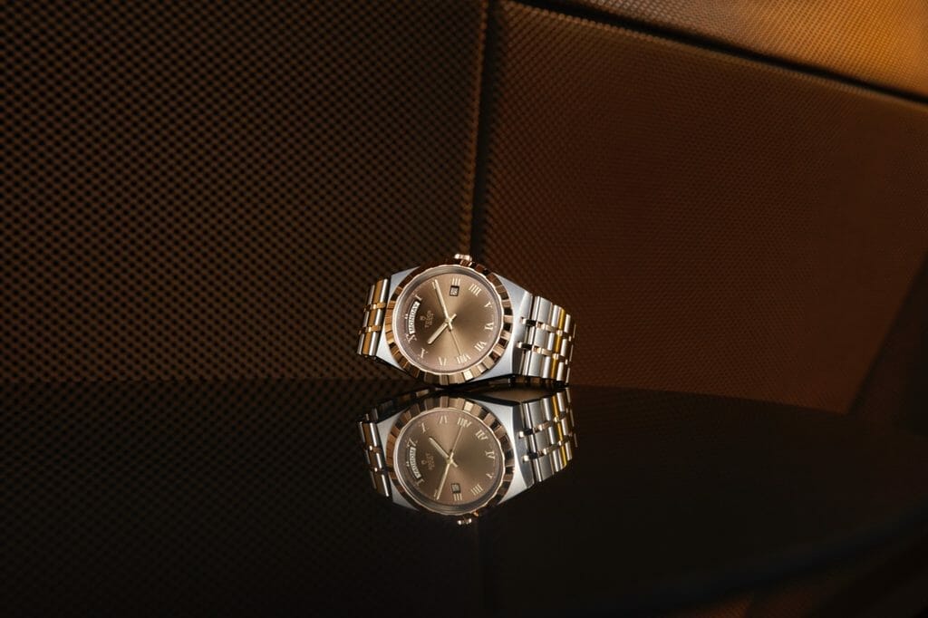 Boitier en acier inoxydable 316L 41, 38, 34 ou 28 mm, finition polie et satinée. Lunette en or jaune crénelée, alternant finitions rainurées et polies. Cadran chocolat non serti. Glace saphir.