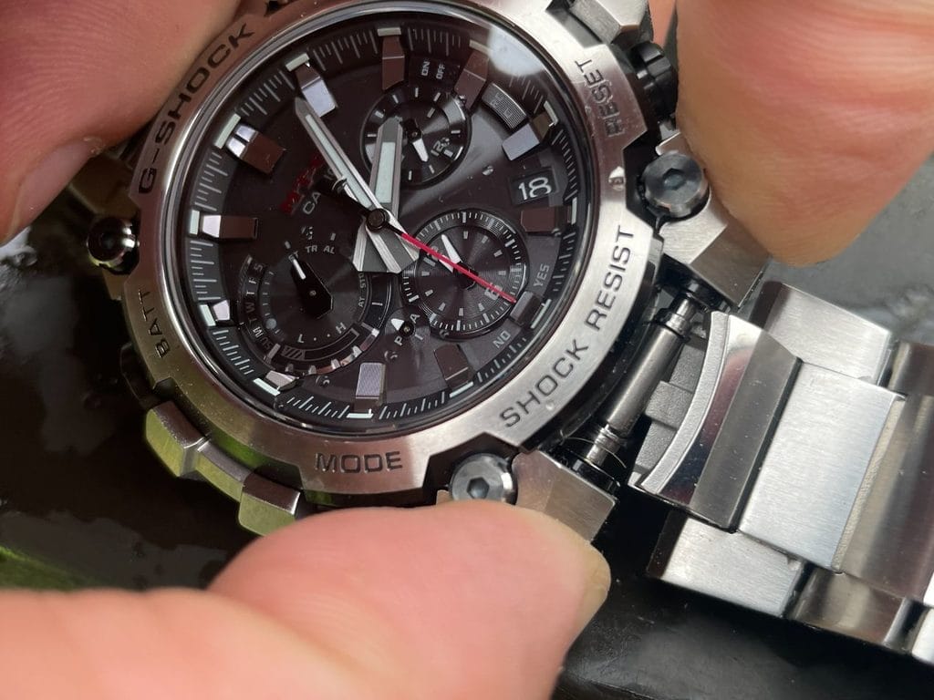 Déverrouillage du bracelet via deux boutons poussoirs latéraux.